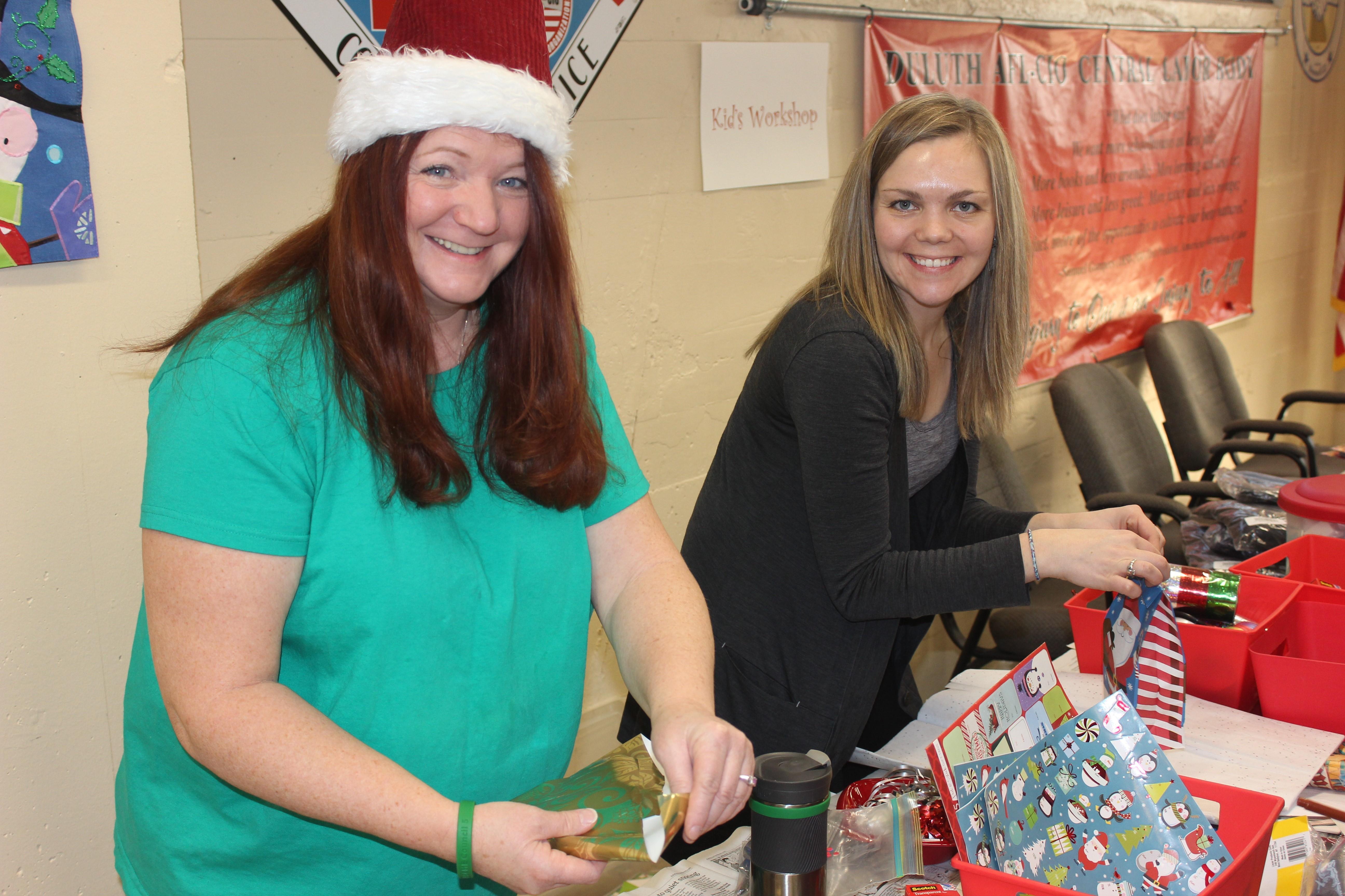 Christina St. Germaine, from Local 1092, helps Local 3558's Rachel Loeffler-Kemp prepare gifts for families at the AFL-CIO Community Services Program's annual kid's holiday party